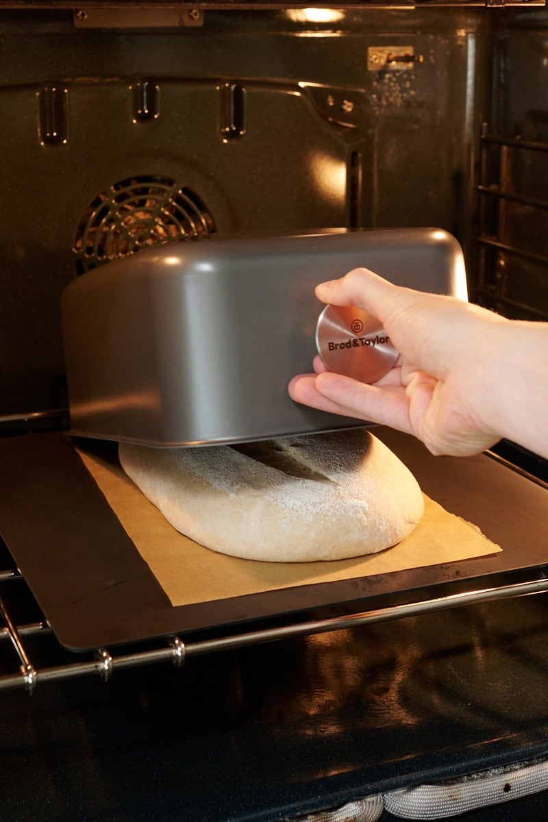 Batard baking shell being placed over dough in the oven