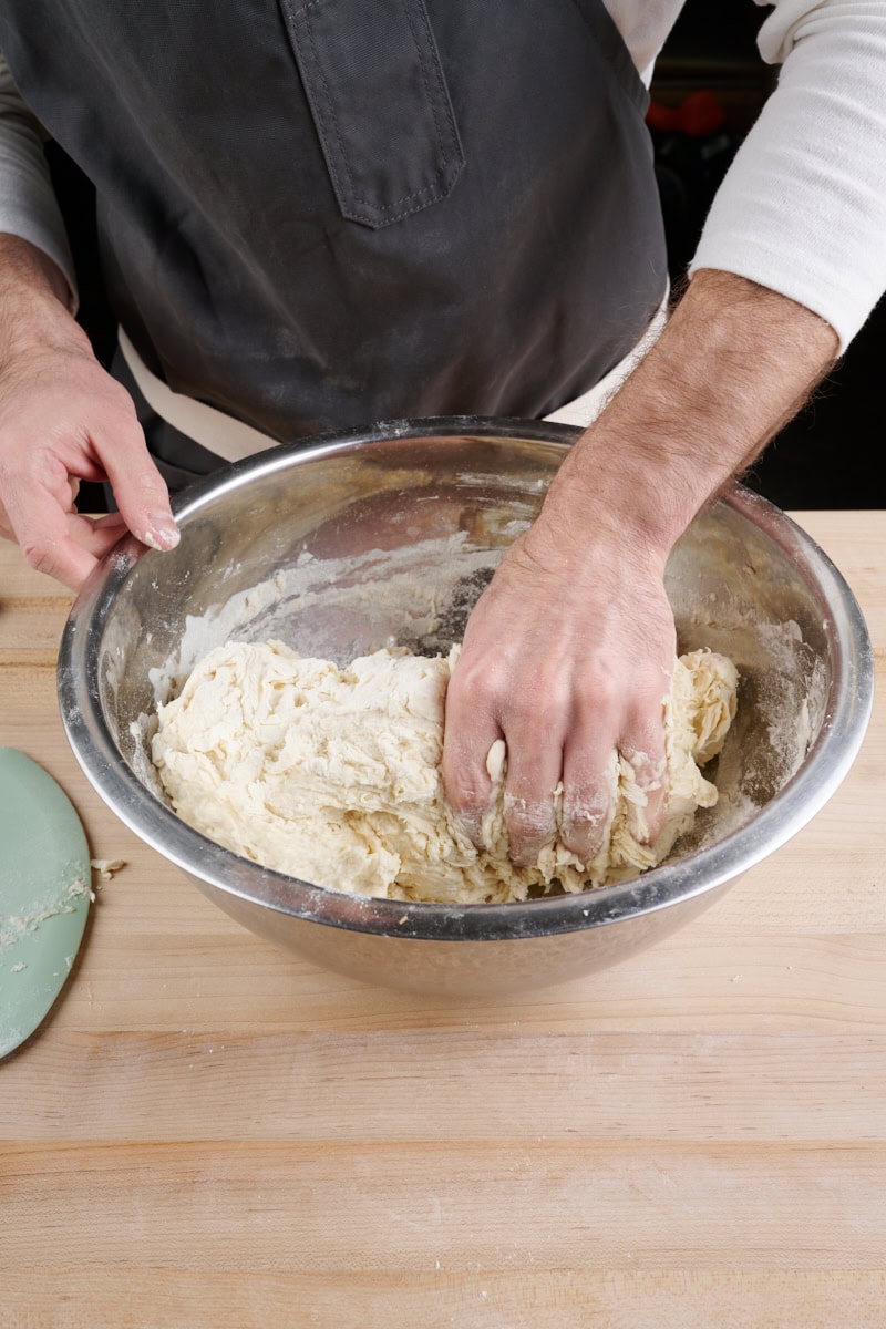 Pinching the dough to strengthen it during mixing.