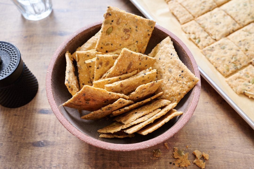 Seeded sourdough discard crackers in a bowl.