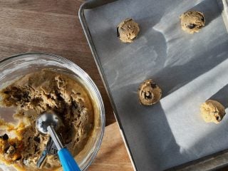 Scooping sourdough starter discard chocolate chip cookie dough for baking.
